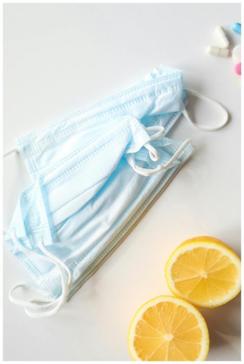 A composition of face masks, lemon halves, and pil