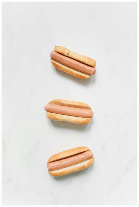 Three plain hot dogs arranged in a minimalist fash