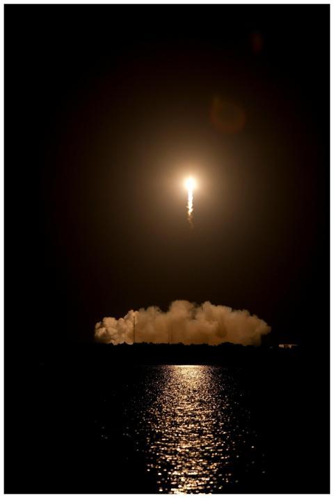 Dramatic rocket launch at night creating vivid ref