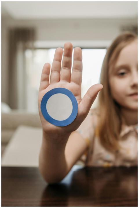 Close-up of a child showing a blue circle sticker