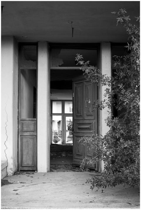 Black and white photo of an abandoned building wit