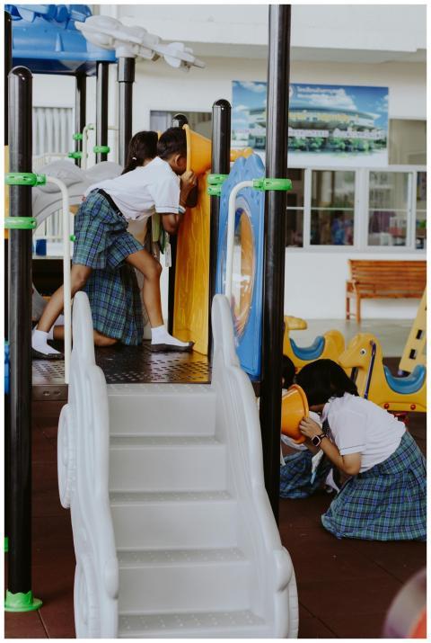 Kids in uniforms enjoying playtime on indoor playg