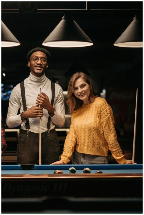 Two friends enjoying a billiards game indoors, smi