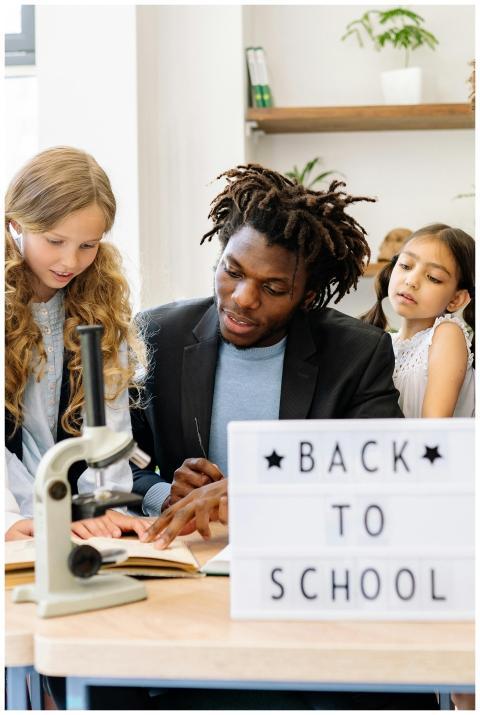 A teacher guiding diverse students in a classroom.