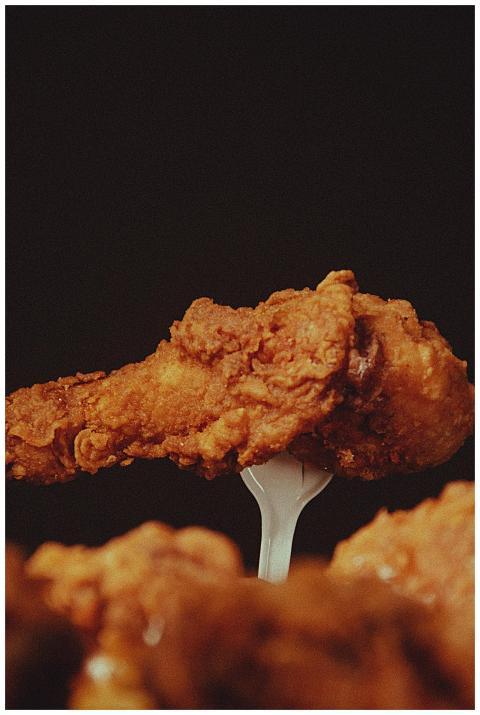 A close-up of a crispy fried chicken wing on a for