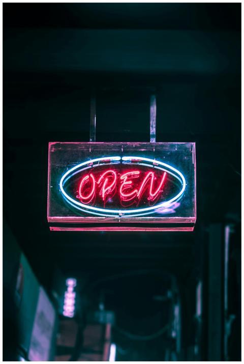 Glowing neon 'Open' sign illuminating the night st