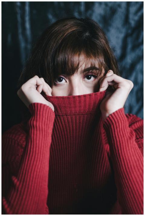 Close-up portrait of a woman in a red sweater, wit