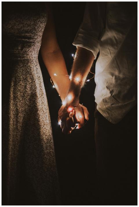 A warm and intimate close-up of a couple holding h