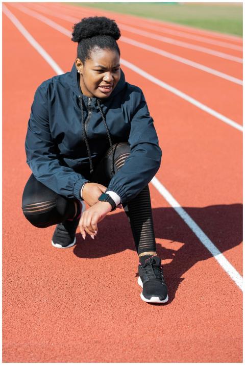 African American athlete in activewear stretching