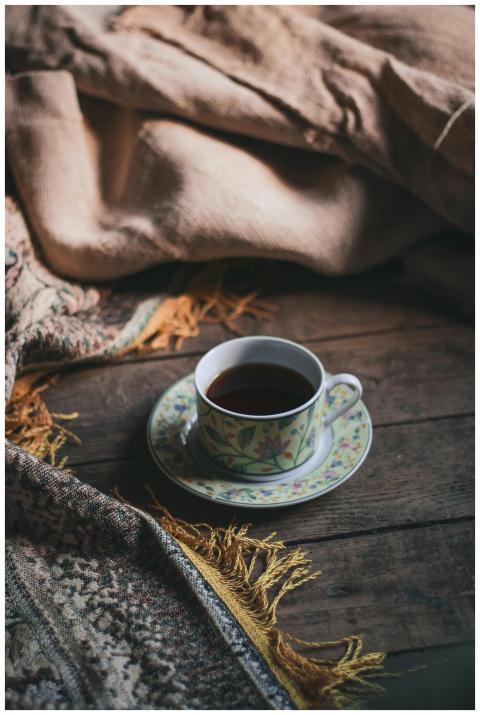 From above of cup of hot tea and saucer placed on