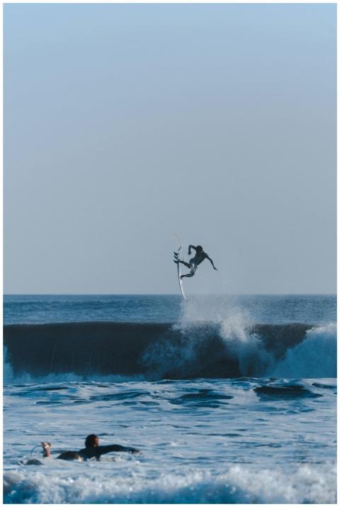 Dynamic surfer performing an aerial trick over oce