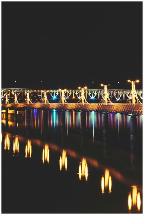 A beautifully lit bridge at night reflecting its l