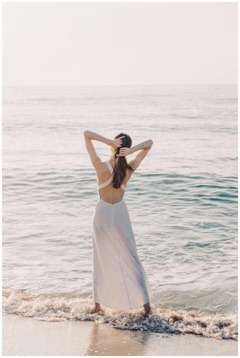 A woman in a white dress enjoys a serene moment by