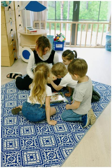 Young children and teacher in a kindergarten readi