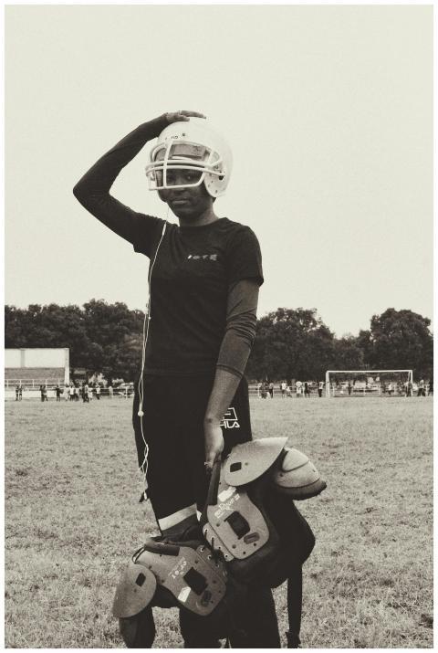 A young woman wearing football gear standing on a