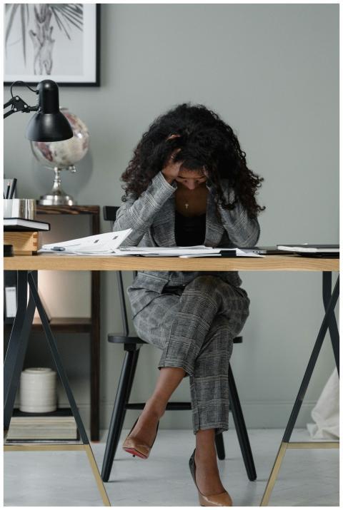 A frustrated businesswoman sitting at a desk, stre