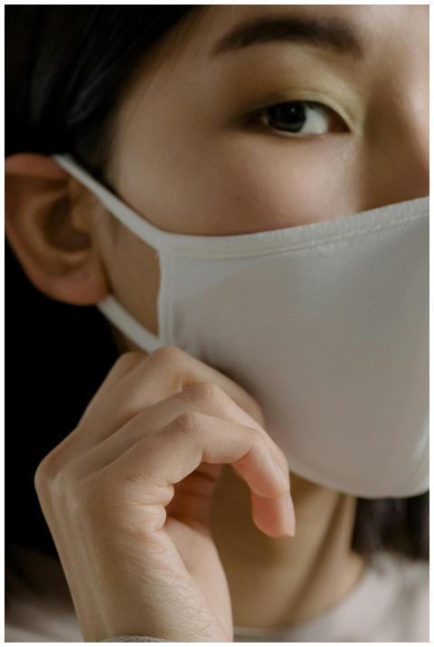 Close-up of an Asian woman wearing a white face ma