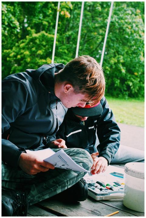 A man and child enjoy outdoor painting together du