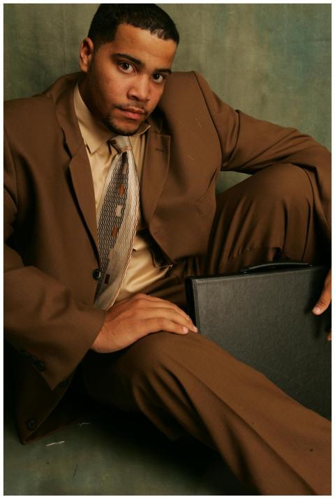 A confident businessman in a brown suit sitting wi