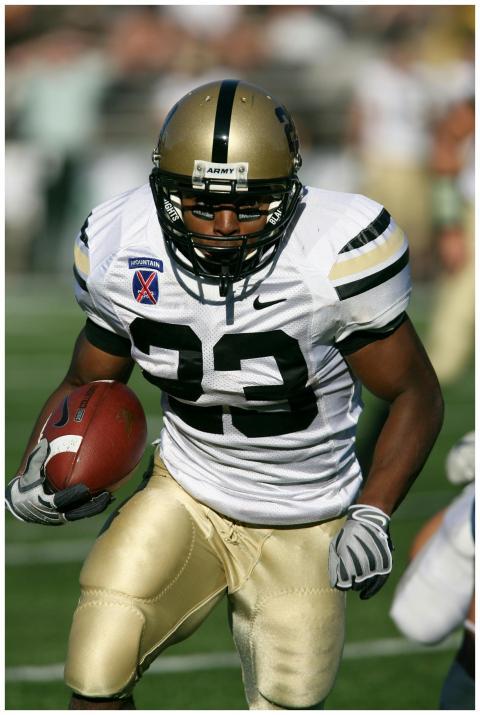 Focused American football player running with ball