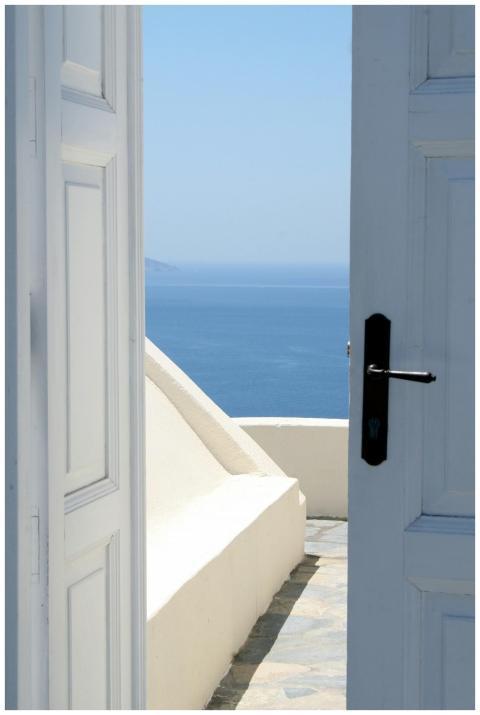 A serene view of the blue sea through an open door