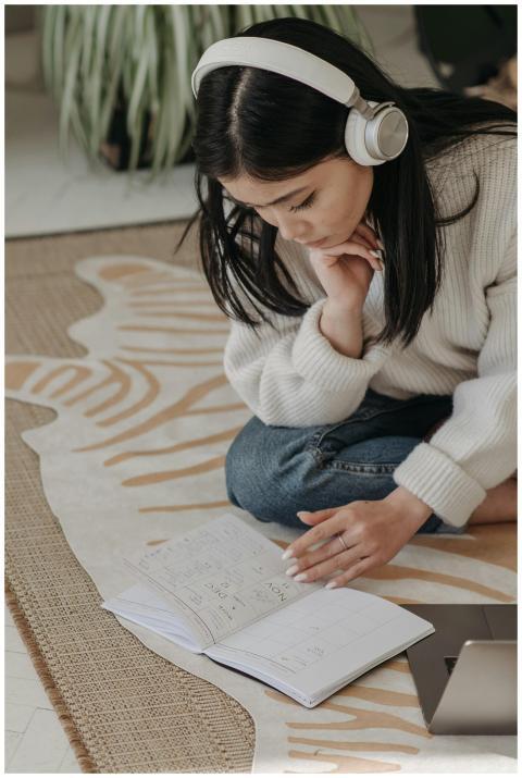 Asian woman sitting and studying with headphones,