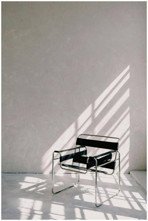 A modern metal chair casting a dramatic shadow on