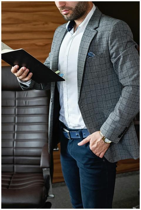 Elegantly dressed businessman reading a book in a