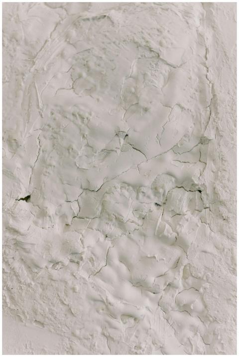Detailed close-up of white cracked plaster texture