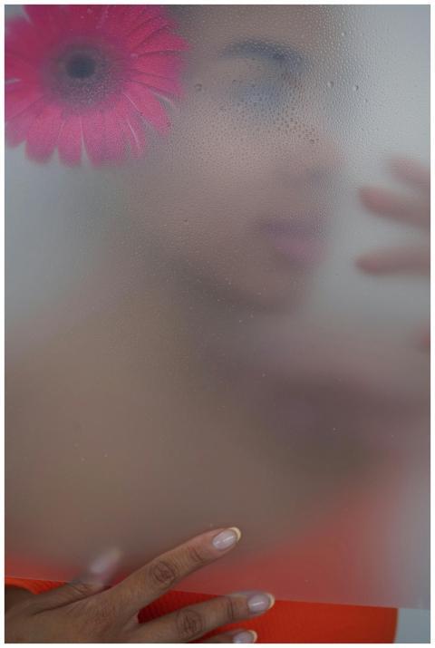 A creative portrait featuring a person behind fros