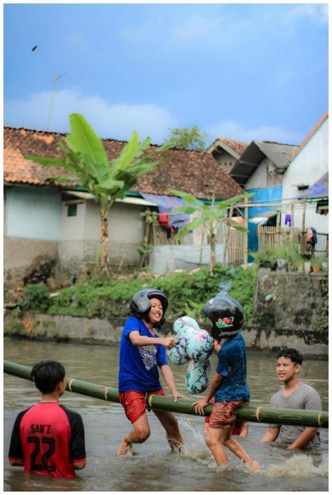 Group of kids wearing helmets playing pillow fight