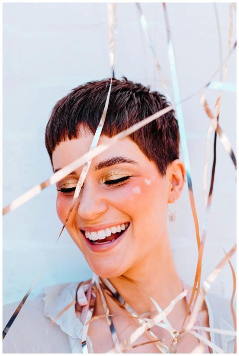 A cheerful woman with short hair smiling joyfully