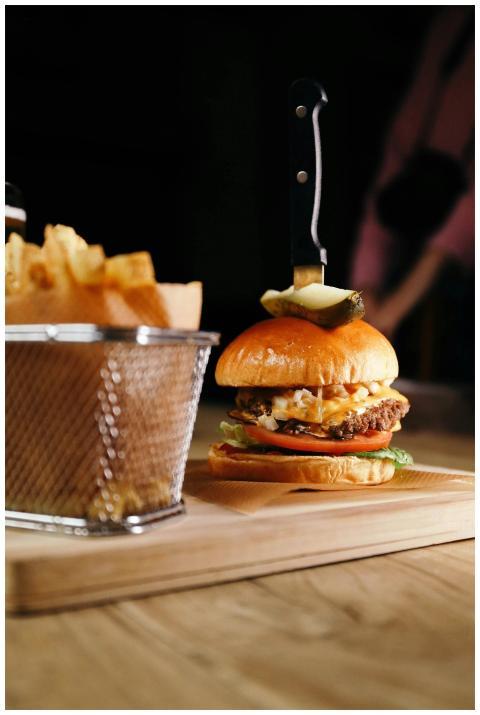 Delicious gourmet burger with fries on a wooden bo