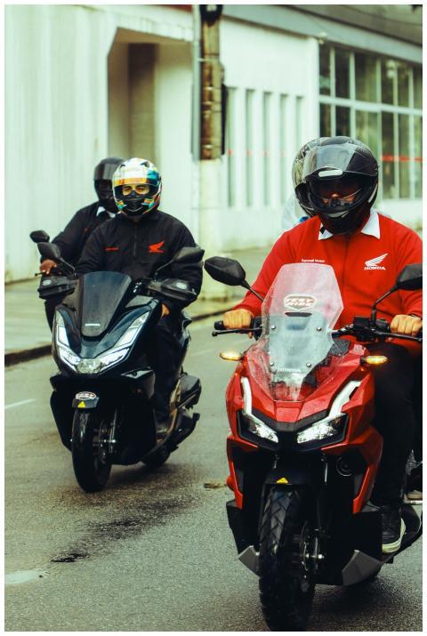 Motorcyclists wearing helmets ride Honda motorcycl