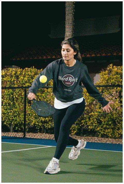 Energetic woman playing pickleball on an outdoor c