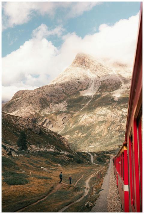 Red train winds through the picturesque mountains