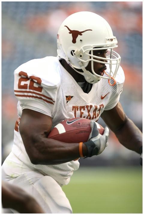 Focused athlete running with football in Texas sta