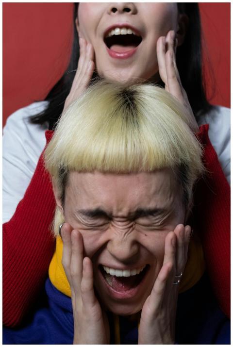 Two young Asian models express surprise and fun in