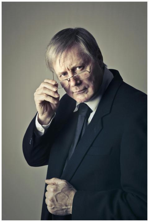 Serious senior adult man with glasses in a suit, c