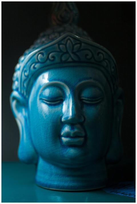 Close-up view of a blue ceramic Buddha head sculpt