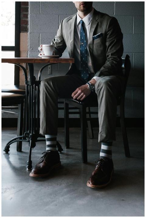 A man in a designer suit enjoys coffee in a chic c