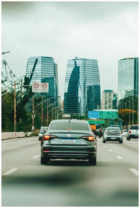 Cars driving on a busy highway with modern skyscra