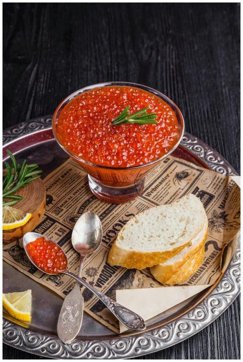 Elegant serving of red caviar with bread and lemon