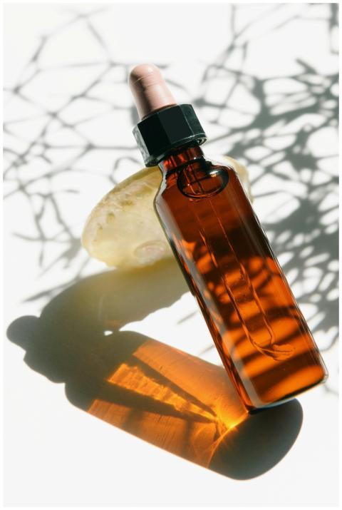 A sleek glass aromatherapy bottle casting artistic