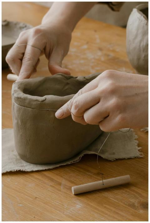 Close-up of hands shaping clay pottery with sculpt