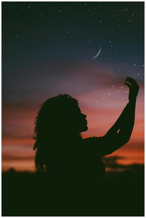 A silhouette of a woman extends her hand towards a