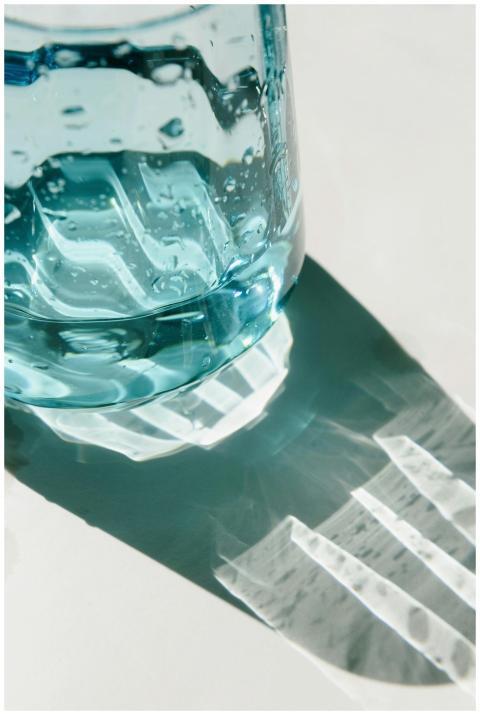 Aesthetic close-up of a blue glass bottle casting