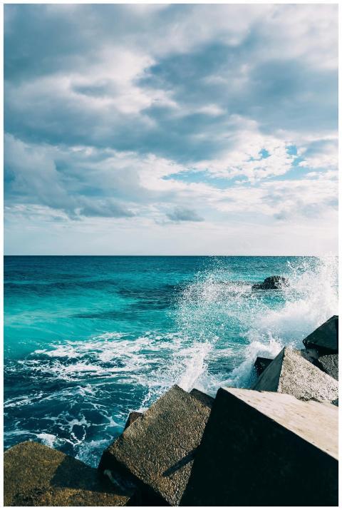 Powerful ocean waves crash against rocky barriers