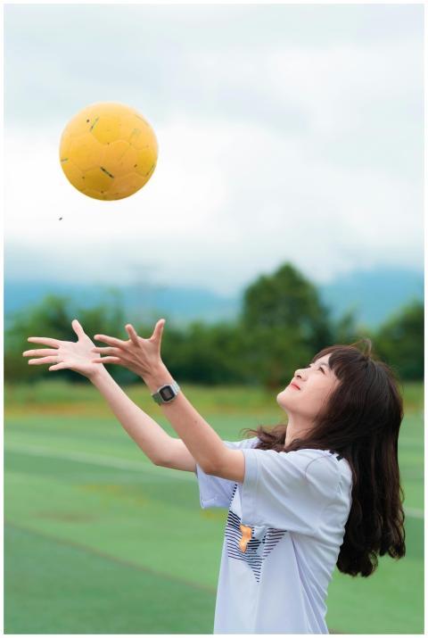 Young woman wearing a white shirt plays soccer out