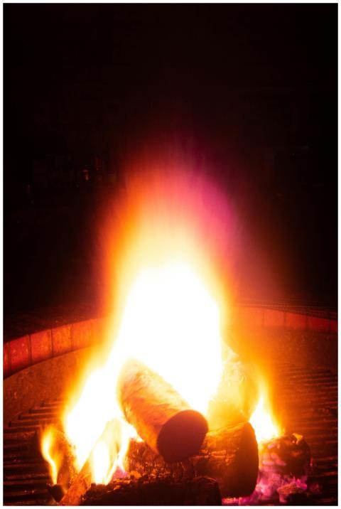 Close-up of a campfire emitting warm flames and em